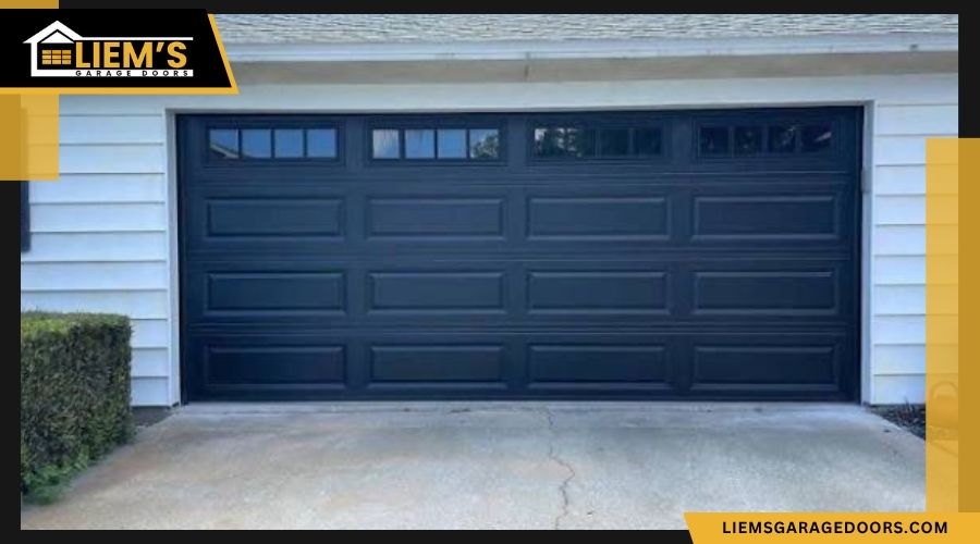 garagedoordimensions Black sectional double garage door with a top row of grid windows framed by white siding and featuring the Liem's Garage Doors logo.