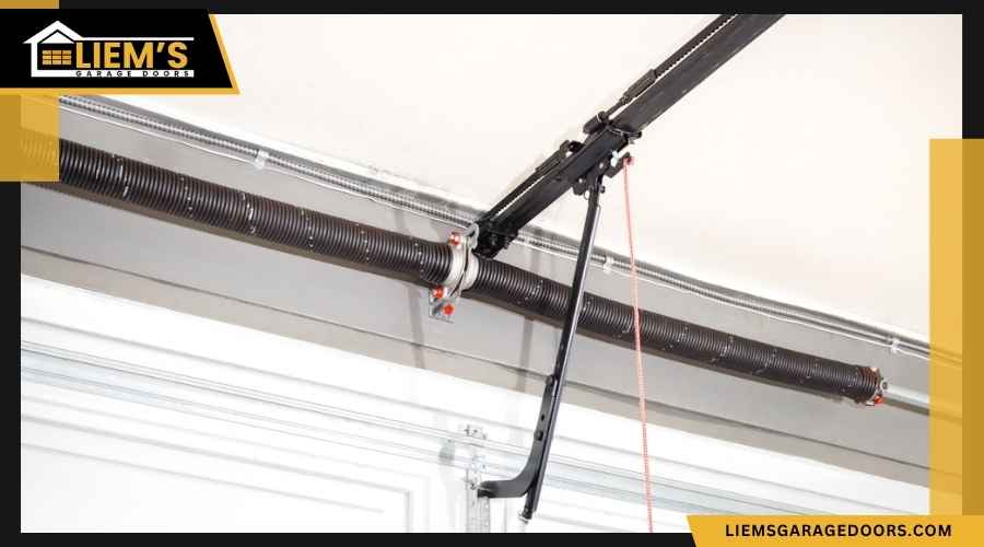 Close up view of a garage door torsion spring cables and pulley mechanism mounted above the door