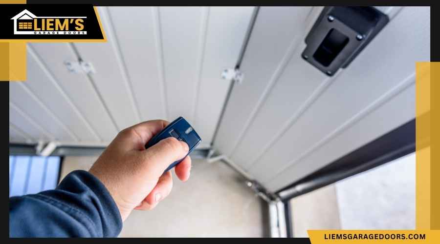 Hand holding a modern garage door remote control inside a car or near a clean garage entrance
